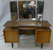 A mid century vintage teak G-Plan dressing table with adjustable triple mirrors above drawers on