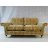 A large Parker Knoll two seater Burghley sofa in Baslow Medalli gold upholstery raised on turned