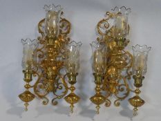 A pair of large brass scrolling floral three branch wall sconces fitted with etched glass storm