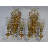 A pair of large brass scrolling floral three branch wall sconces fitted with etched glass storm