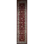 A Ziegler style Runner with all over scrolling foliate motifs on a burgundy field within floral