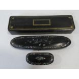 Three antique hand painted black papier-mâché snuff boxes, a glasses case with abalone chip inlaid