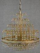 A brass framed four tier wedding cake style chandelier with crystal drops. H.50 D.43cm