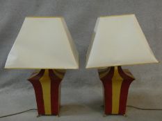 A pair of shaped and painted table lamps on brass lion's paw feet. H.74cm