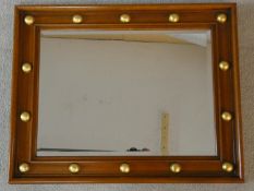 A walnut framed wall mirror with bevelled plate and gilt roundels to the frame. H.76 W.60cm