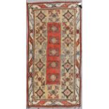 A Turkish Millas rug with repeating central flowerhead motif contained within broad stylised borders