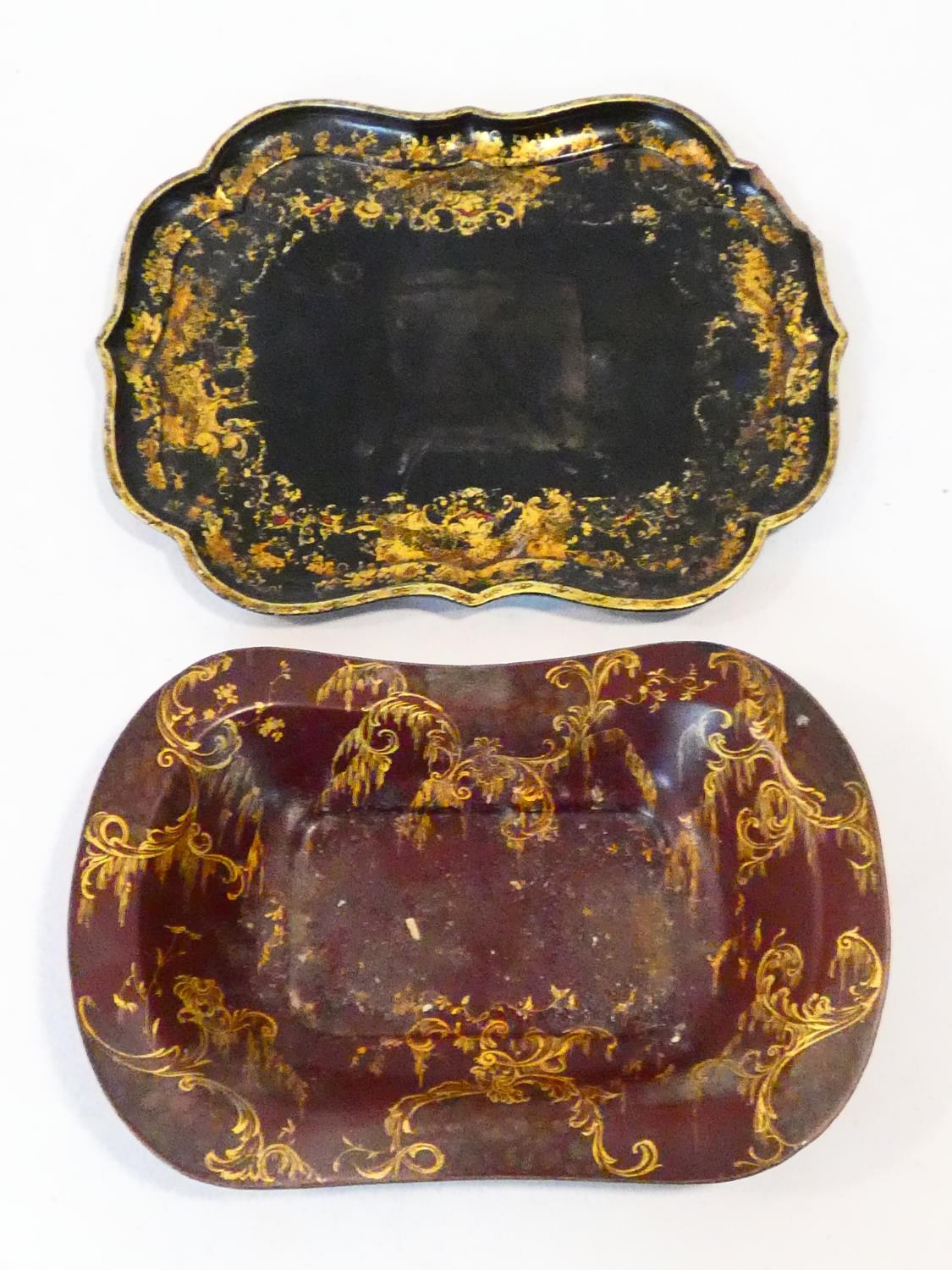 A 19th century black lacquered papier mache tray with gilt floral painted decoration and a similar