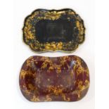 A 19th century black lacquered papier mache tray with gilt floral painted decoration and a similar