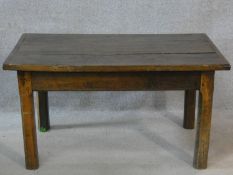 A possibly 17th century country elm low table with planked and cleated top raised on square