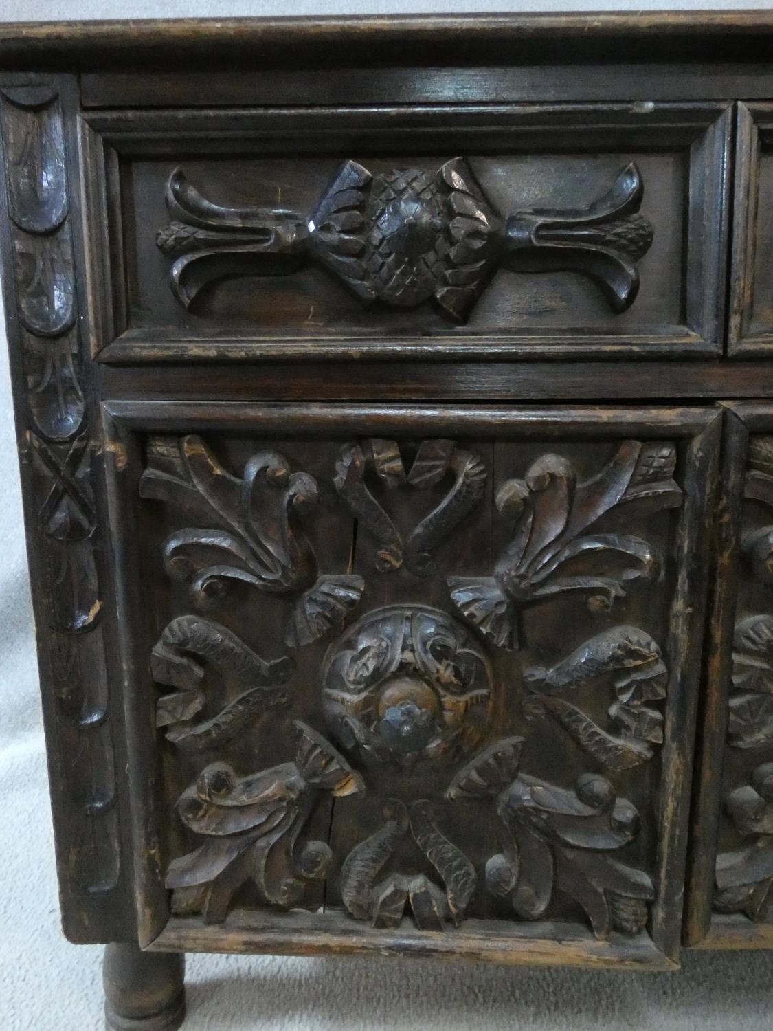 An antique oak side cabinet with carved drawers and doors on circular squat supports. H.73 W.93 D. - Image 3 of 8