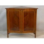 An Edwardian figured mahogany and satinwood inlaid serpentine fronted corner cabinet on square