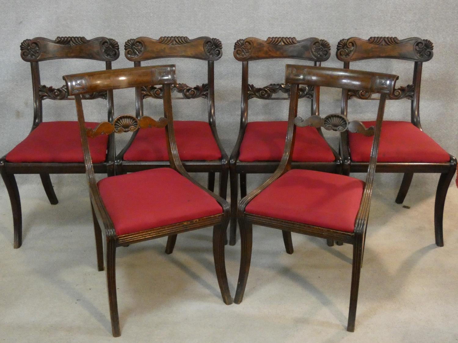 A set of six Regency mahogany bar back dining chairs with shell carving to the backs above drop in