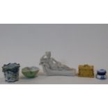 A collection of ceramics and a carved stone sculpture. A carved stone sculpture of a lady