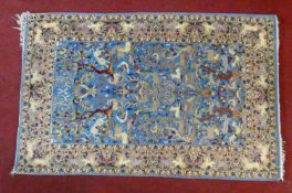 A Persian rug with all over bird, animal and foliate design on a sky blue ground contained by