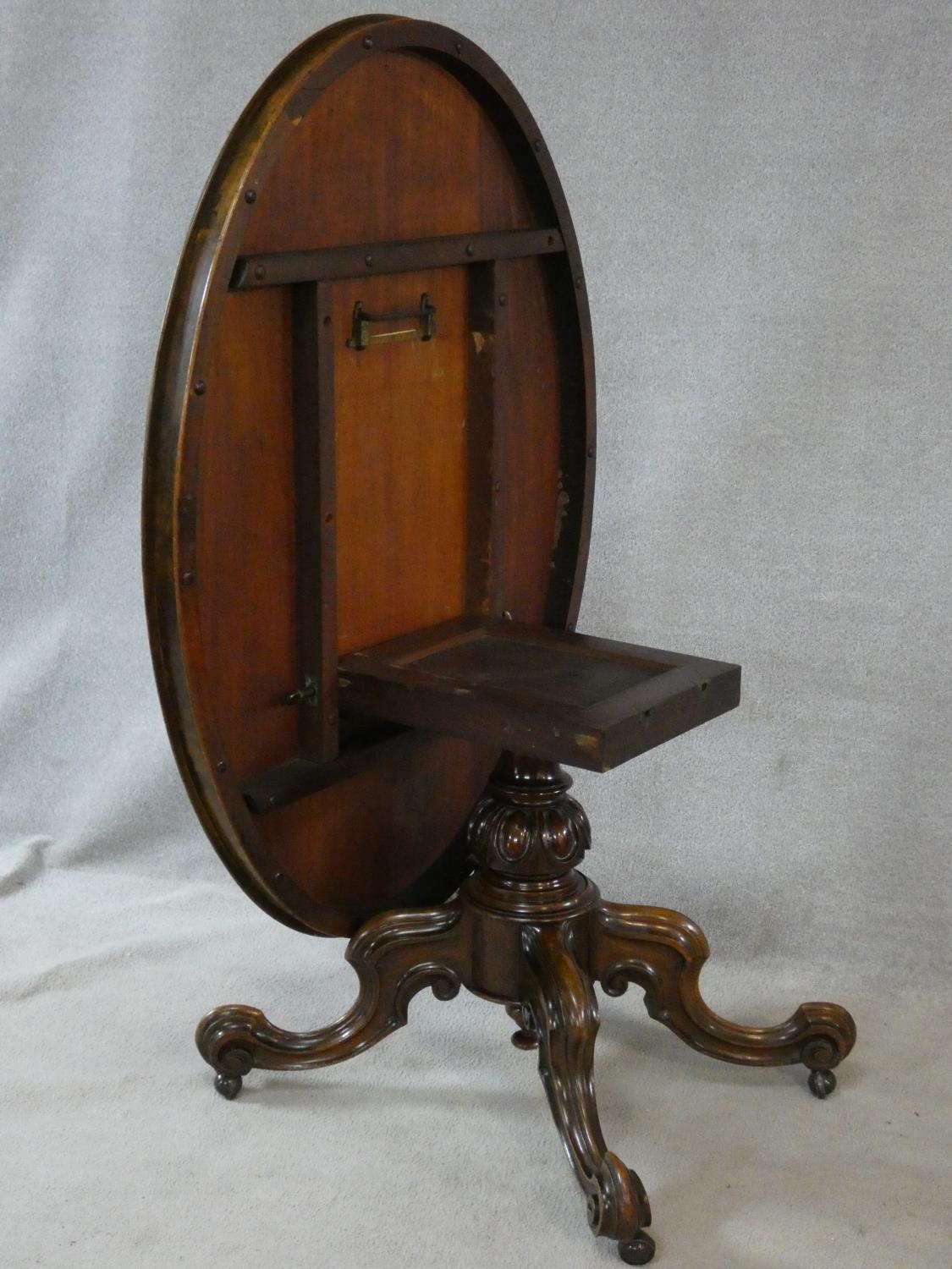 A Victorian burr walnut tilt top dining table on quatreform carved swept supports. H.72 L.137 W. - Image 4 of 4