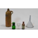 A collection of antique pharmaceutical items. Including a clear glass stemmed eye bath, a white