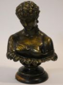 An antique bronzed plaster bust of a classical style woman on stepped carved ebonised circular base.