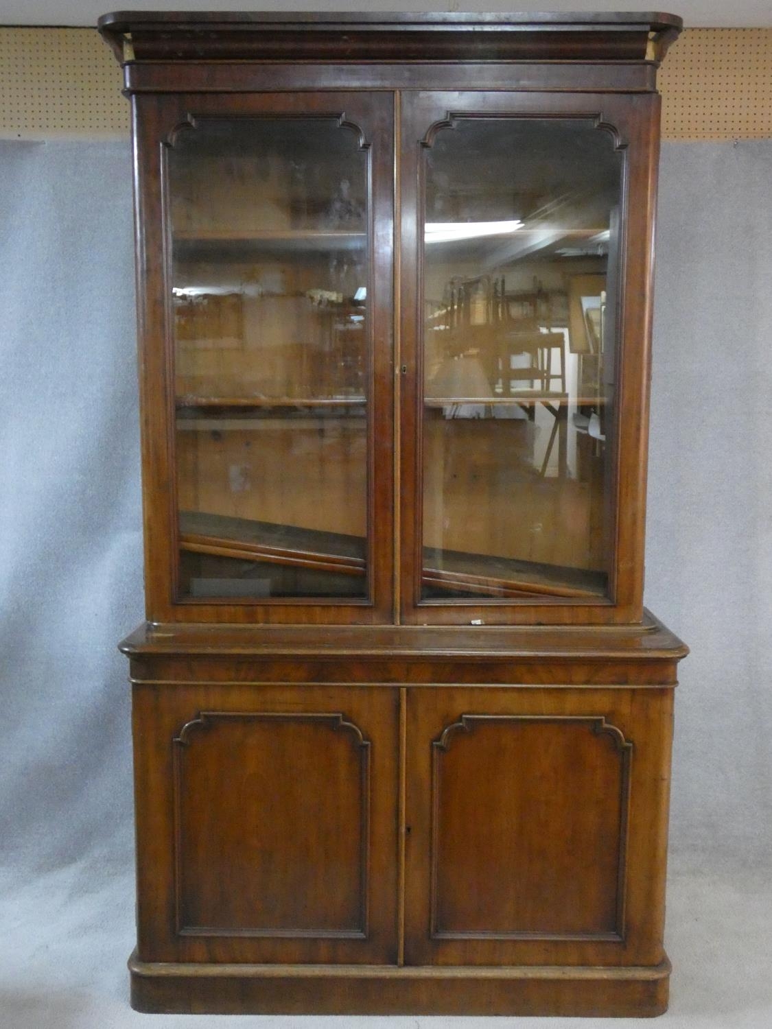 A Victorian mahogany library bookcase with upper glazed doors enclosing book shelves above base