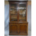 A Victorian mahogany library bookcase with upper glazed doors enclosing book shelves above base