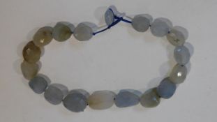 A statement faceted Chalcedony pebble necklace with a silk chord loop clasp. Composed of graduated