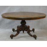 A Victorian burr walnut tilt top dining table on quatreform carved swept supports. H.72 L.137 W.