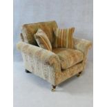 A Parker Knoll Burghley armchair in Baslow Medalli gold upholstery raised on turned tapering