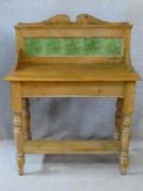 A Victorian pine washstand with Art Nouveau tiled back raised on turned stretchered supports. H.