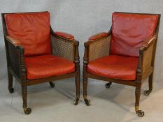 A pair of Georgian mahogany framed library bergere armchairs with leather upholstered seat and