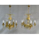A pair of gilt metal five branch chandeliers with crystal drops. H.80 D.44cm