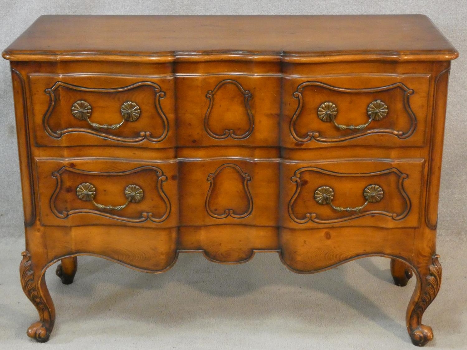 A French provincial chestnut two drawer commode on carved cabriole supports. H.87 W.117 D.48cm