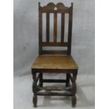 An antique oak hall chair with shaped and pierced rail back above panel seat on turned and