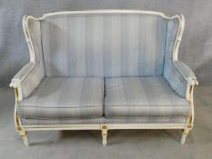 A Louis XVI style gilt and with painted two seater sofa in pale damask upholstery. H.93 L.136 D.77cm