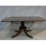 A Regency mahogany tilt top dining table on reeded swept quadruped supports terminating in brass cap