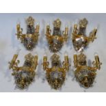 A set of six gilt metal twin branch wall candelabras with crystal drops. H.38cm