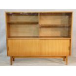 A 1960's vintage teak Beaver and Tapley Multi Width display cabinet on shaped splay supports. H.