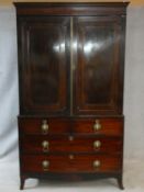 A Regency mahogany linen press with stepped dentil cornice above panel doors enclosing interior