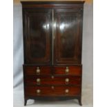 A Regency mahogany linen press with stepped dentil cornice above panel doors enclosing interior