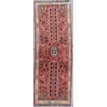 A Persian Shiraz runner with central medallion and trellis design on salmon pink ground within