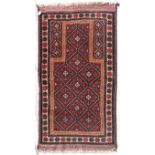 An Afghan Balouch prayer rug with repeating lozenge design within flowerhead border. L.160xW.85cm