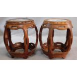 A pair of Chinese carved and pierced hardwood barrel stools with inset hand painted porcelain tile
