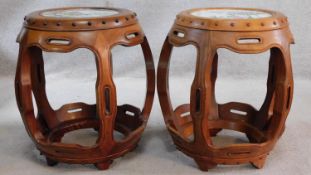 A pair of Chinese carved and pierced hardwood barrel stools with inset hand painted porcelain tile