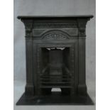 An ornately cast 19th century iron fire surround, mantel shelf and insert with grate on marble