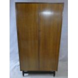 A mid century vintage teak G-Plan fitted compactum wardrobe on ebonised feet with Ebenezer Gomme