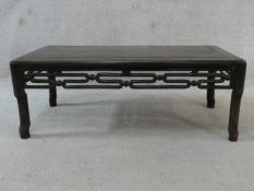 A Chinese hardwood low table with carved and pierced frieze on shaped supports. H.27 L.72 W.38cm