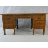 A mid century oak pedestal desk on square tapering supports. H.77 W.153 D.78cm