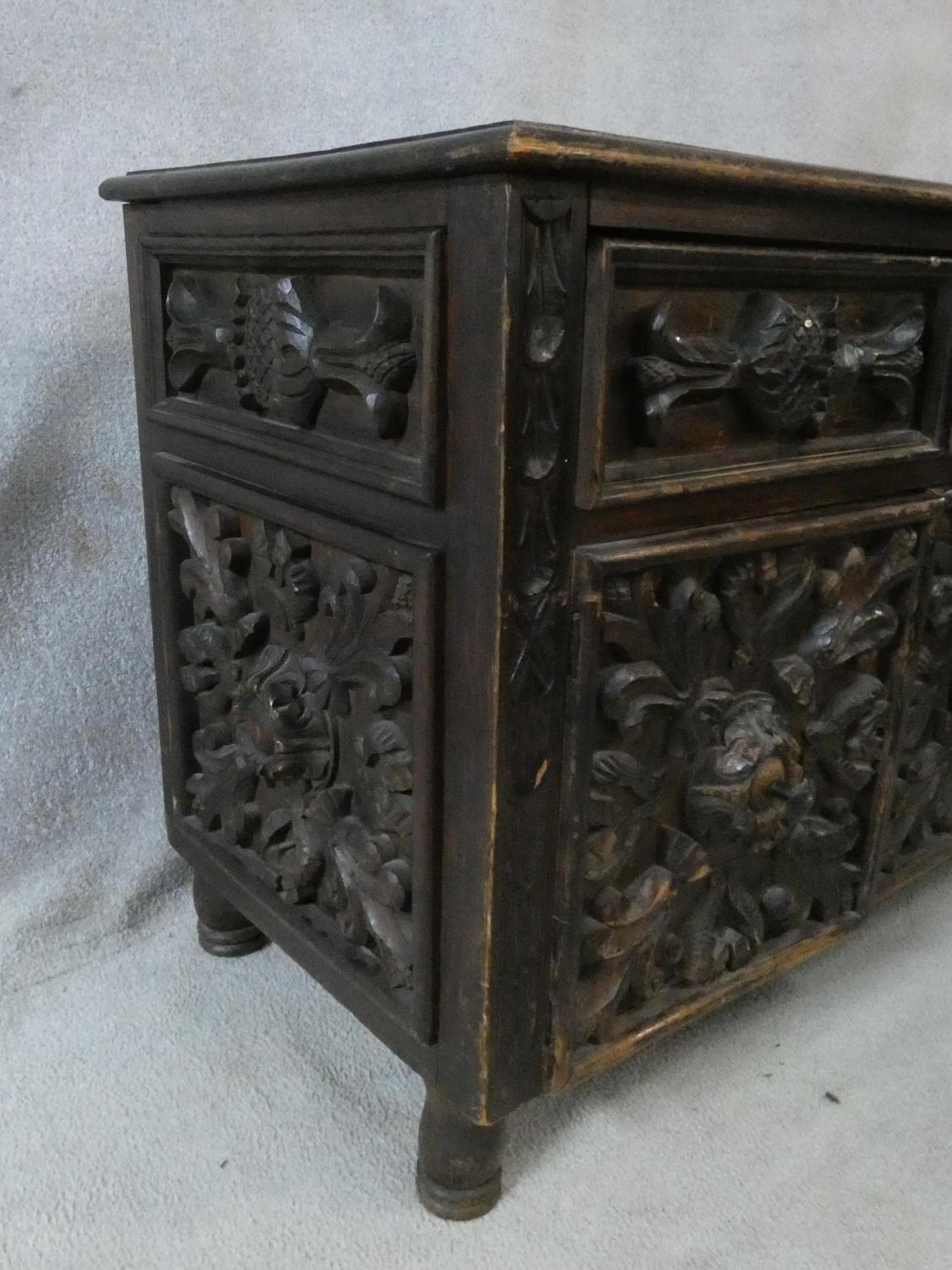 An antique oak side cabinet with carved drawers and doors on circular squat supports. H.73 W.93 D. - Image 6 of 8