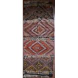 A Moroccan Kilim with polychrome diamond medallions contained within geometric bands. L.260xW.110cm