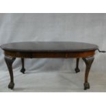 A mid century mahogany Georgian style dining table with gadrooned edge, wind out action and extra