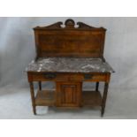 A late 19th century walnut washstand with carved superstructure and veined marble top above a pair
