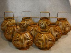 Nine Chinese style storm lanterns in caned cases with carrying handles. H.35cm